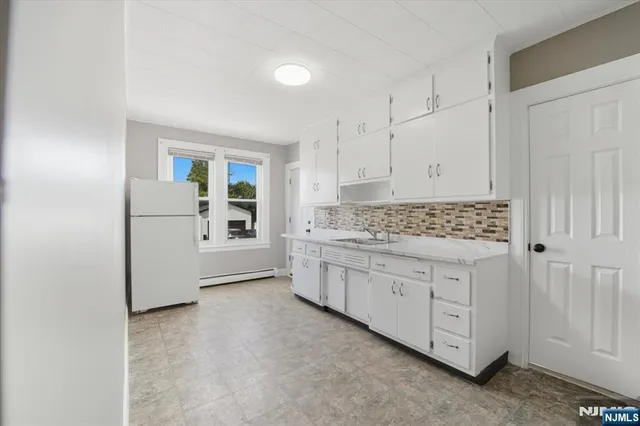 a kitchen with granite countertop white cabinets and white appliances
