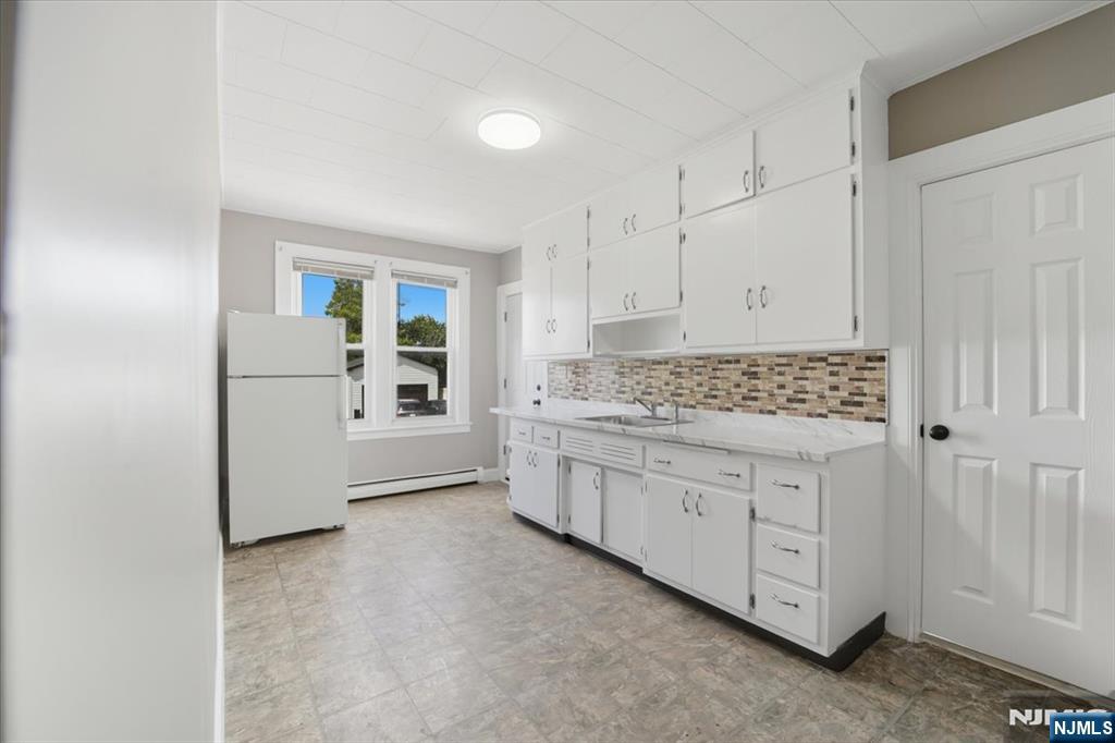 102 Exton Avenue North Arlington, NJ 07031 - Photo 18 of 18 a kitchen with granite countertop white cabinets and white appliances