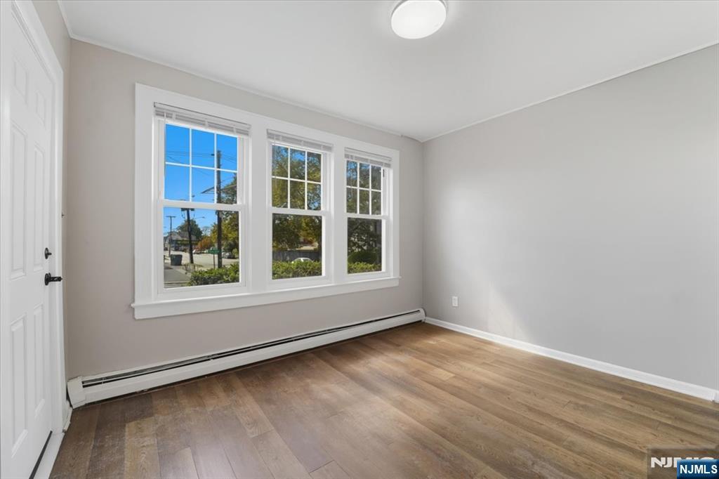 102 Exton Avenue North Arlington, NJ 07031 - Photo 2 of 18 an empty room with wooden floor and windows