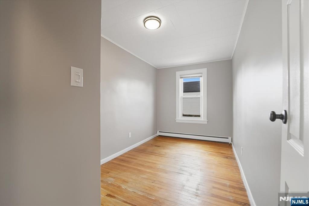 102 Exton Avenue North Arlington, NJ 07031 - Photo 9 of 18 a view of an empty room with wooden floor and a window