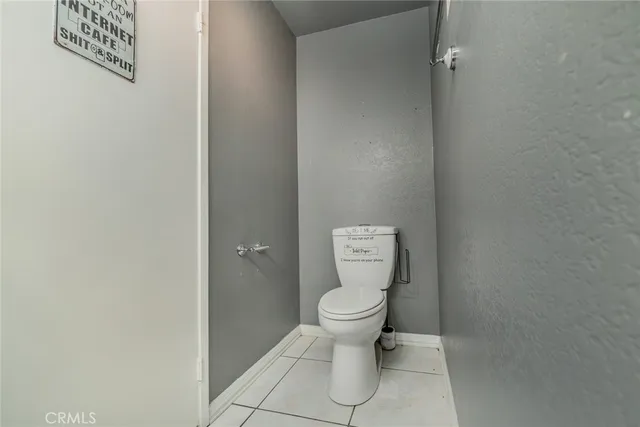 a white toilet sitting next to a white wall