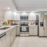 a kitchen with white cabinets and white appliances