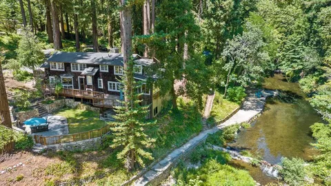 a view of swimming pool with lawn chairs and plants