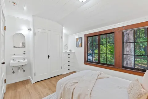a view of a house with a small yard plants and large tree