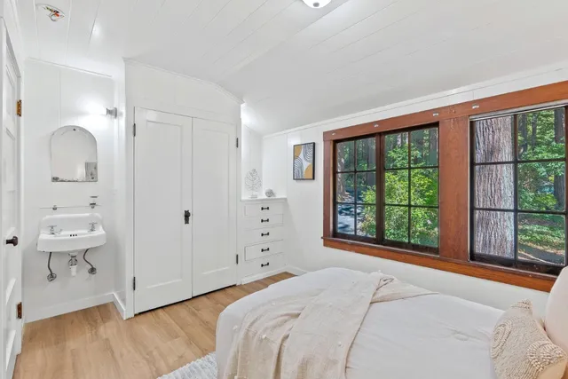 a view of a house with a small yard plants and large tree