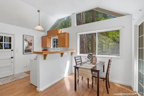 a view of a chairs and table on wooden deck with lake view
