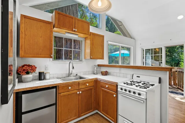 a view of swimming pool with lawn chairs and plants