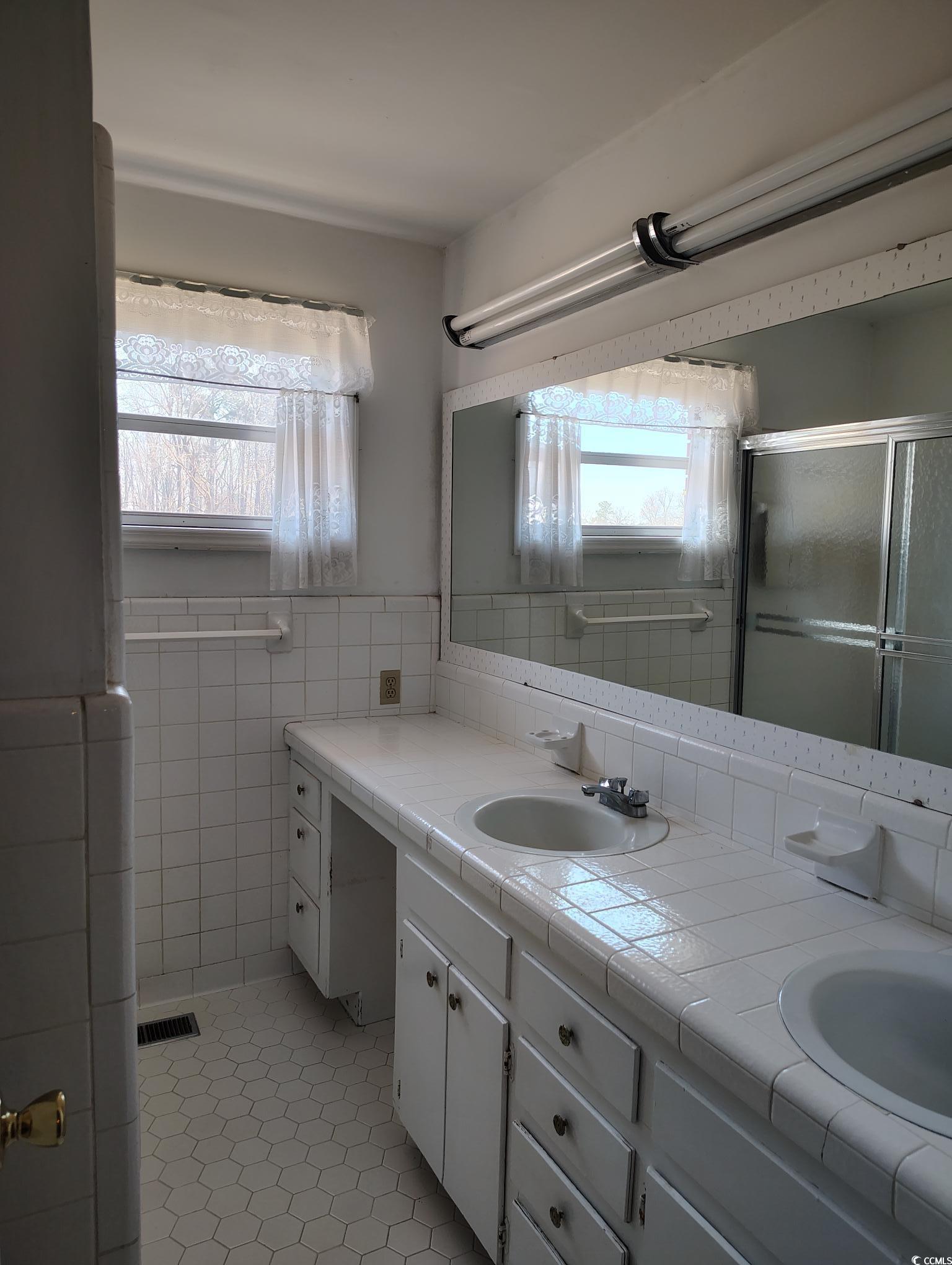 1375 Kenny Jordan Road Tabor City, NC 28463 - Photo 12 of 15 Full bath with tile walls, double vanity, visible vents, a sink, and tile patterned flooring
