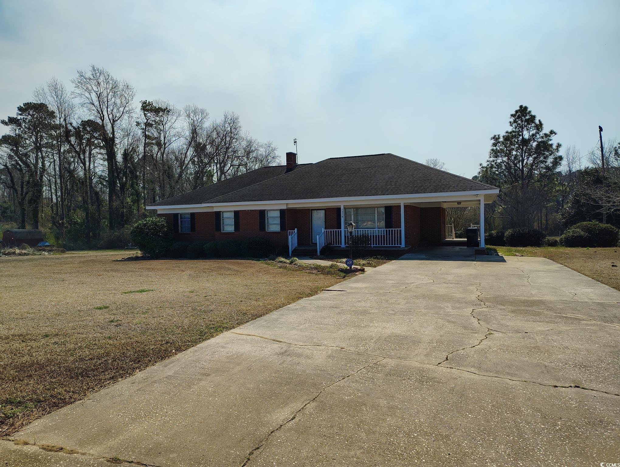 1375 Kenny Jordan Road Tabor City, NC 28463 - Photo 2 of 15 Single story home with covered porch, concrete driveway, a carport, a front lawn, and a chimney