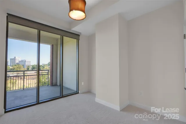 an empty room with sliding glass door and garden
