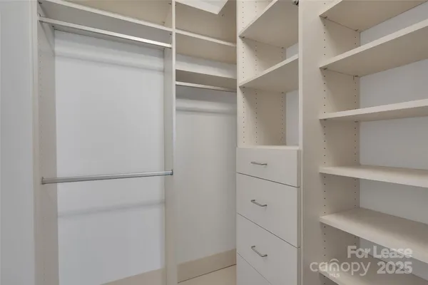 a view of walk in closet with empty racks