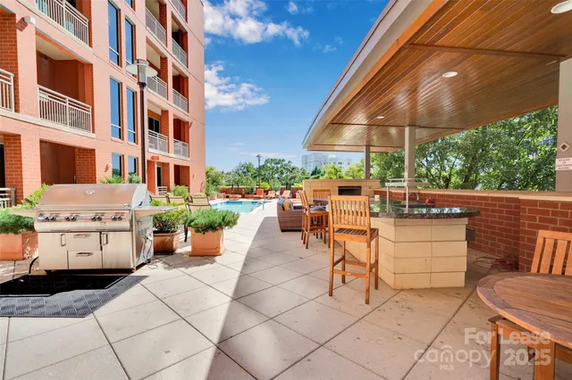 a view of a patio with a dining table and chairs under an umbrella