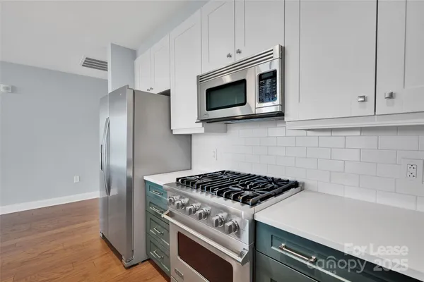 a kitchen with stainless steel appliances a stove a microwave and cabinets