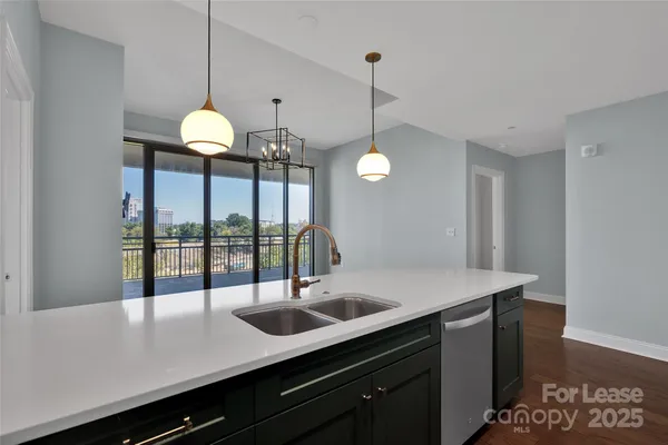 a kitchen with a sink a counter space and a chandelier