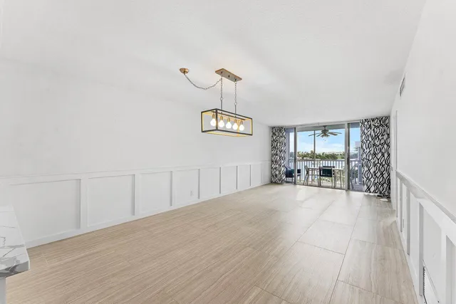 a view of a room with a large window and wooden floor