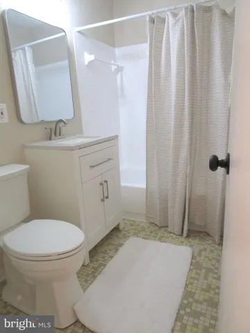 a bathroom with a toilet a sink and shower