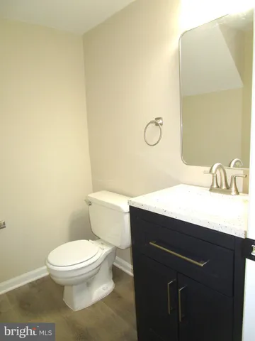 a bathroom with a granite countertop toilet and a sink