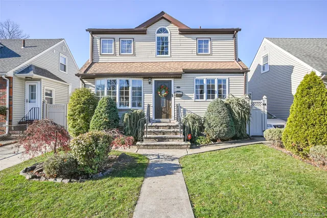 a front view of a house with a yard and potted plants