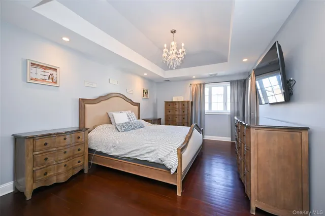 a bedroom with a bed chandelier and a window