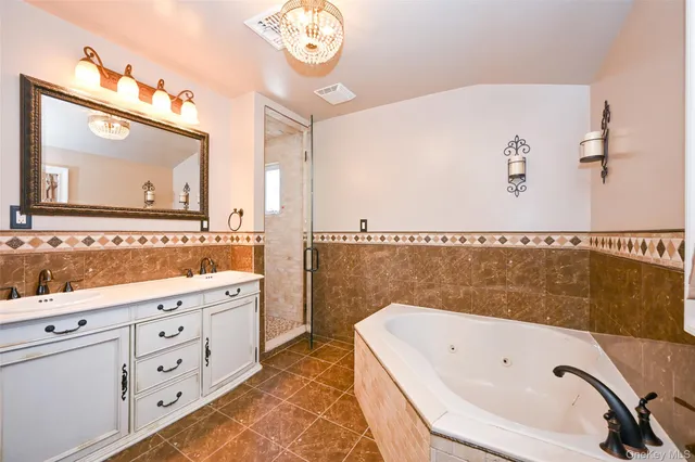 a bathroom with a tub a sink and a large mirror