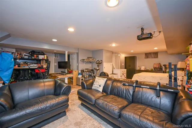 a living room with furniture kitchen view and a chandelier