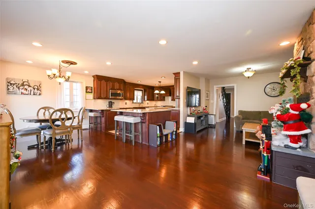 a living room with lots of furniture and kitchen view with wooden floor