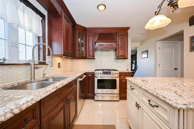 a kitchen with granite countertop a sink stainless steel appliances and cabinets