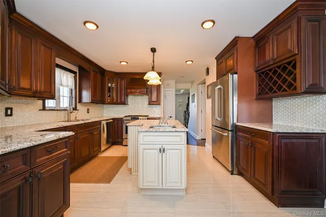 a large kitchen with stainless steel appliances granite countertop a stove refrigerator a sink dishwasher and wooden cabinets with wooden floor