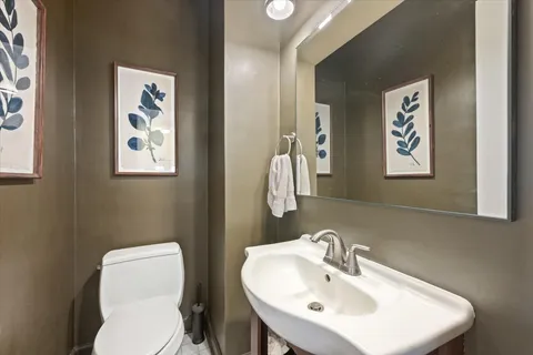 a bathroom with a toilet a sink and mirror