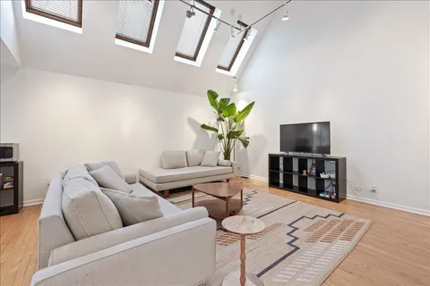 a living room with furniture a flat screen tv and a table