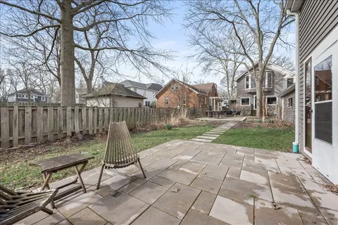 a view of backyard with table and chairs and wooden fence