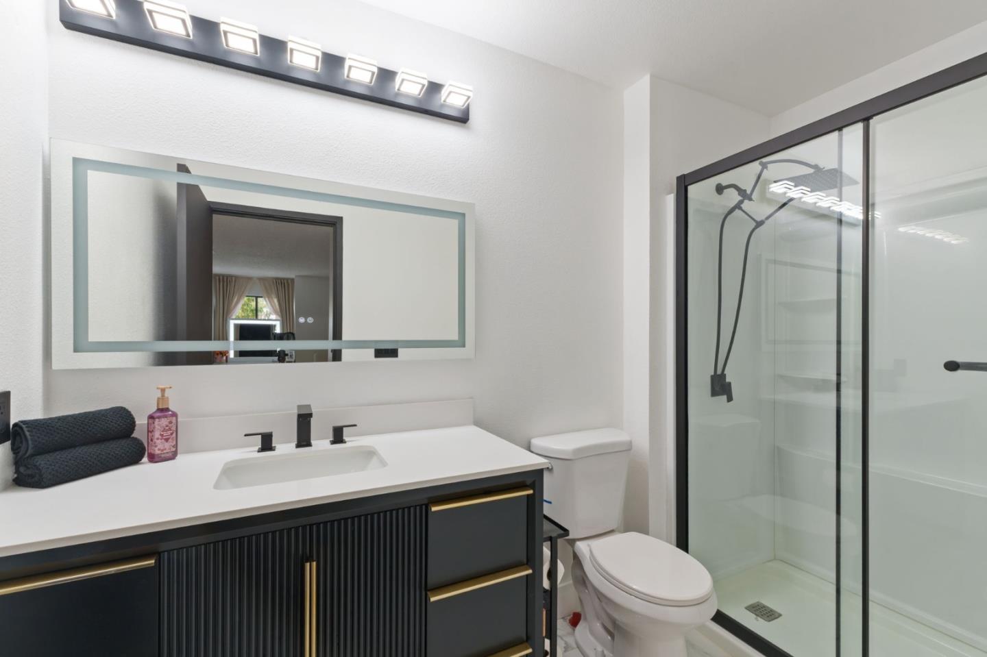 2422 North Main Street, Unit F Salinas, CA 93906 - Photo 21 of 22 a bathroom with a sink a toilet a mirror and shower