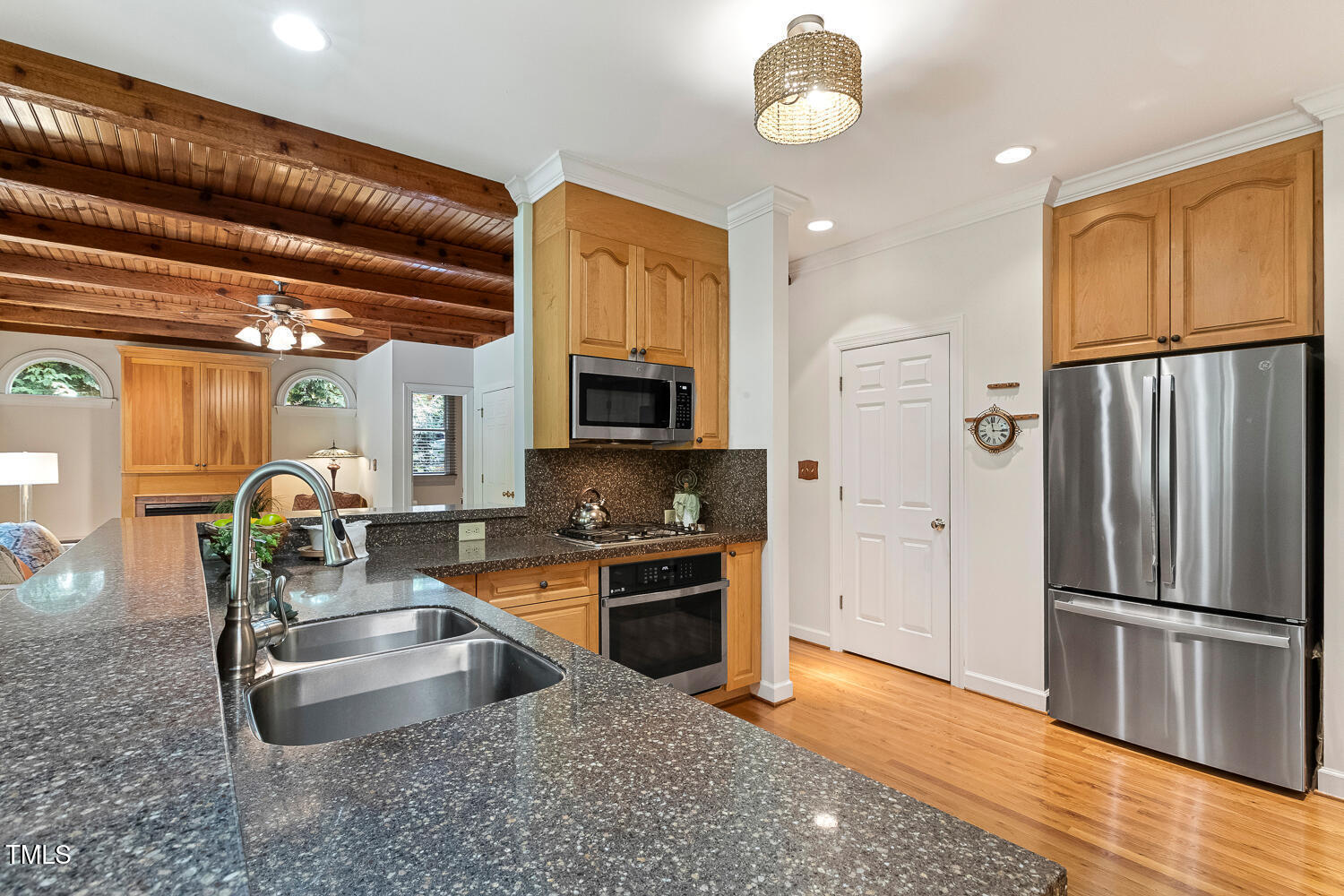 101 Cardiff Place Chapel Hill, NC 27516 - Photo 19 of 82 a kitchen with stainless steel appliances granite countertop a refrigerator a stove and a sink with wooden floor