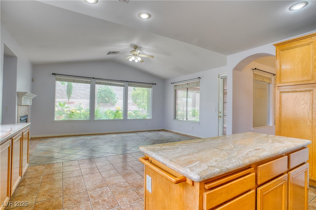 2383 Rainswept Avenue Henderson, NV 89052 - Photo 61 of 62 Kitchen featuring vaulted ceiling, light tile patterned flooring, open floor plan, a center island, and a fireplace