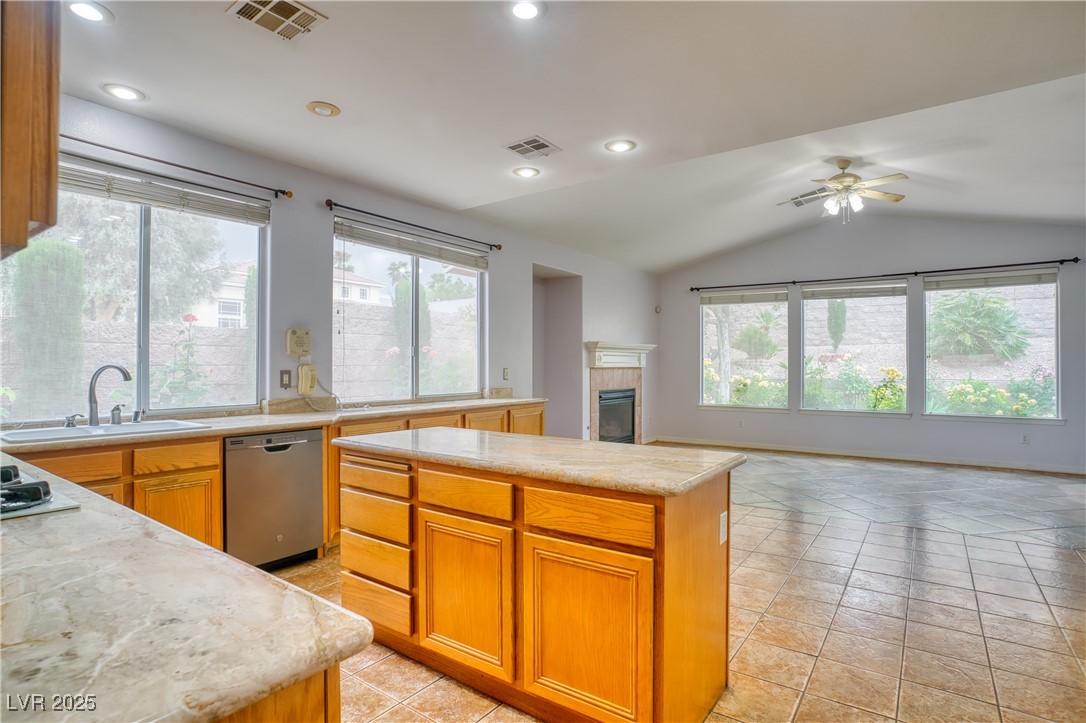 2383 Rainswept Avenue Henderson, NV 89052 - Photo 62 of 62 Kitchen featuring a tiled fireplace, light tile patterned floors, dishwasher, a kitchen island, and open floor plan