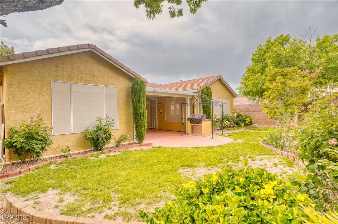 2383 Rainswept Avenue Henderson, NV 89052 - Photo 38 of 62 Rear view of house featuring a tile roof, stucco siding, a lawn, and a patio area