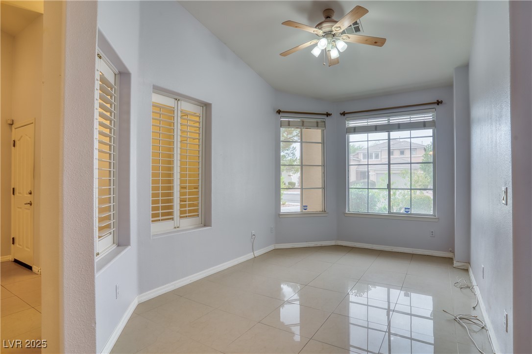 2383 Rainswept Avenue Henderson, NV 89052 - Photo 10 of 62 Empty room with light tile patterned floors, a ceiling fan, and lofted ceiling