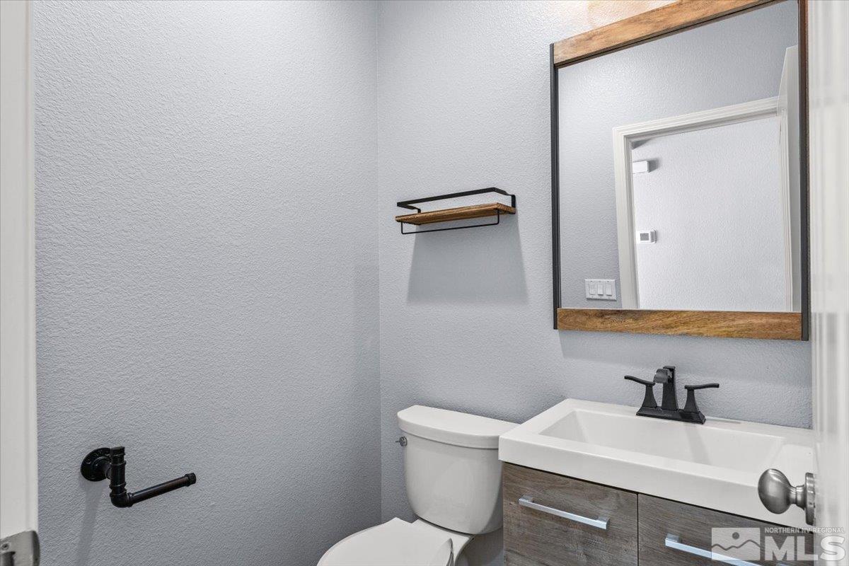 11215 Torino Way Reno, NV 89521 - Photo 8 of 21 a bathroom with a sink a toilet and mirror