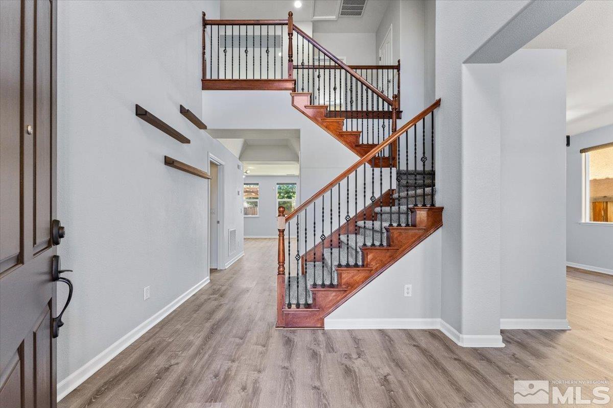 11215 Torino Way Reno, NV 89521 - Photo 10 of 21 a view of staircase with wooden floor and white walls