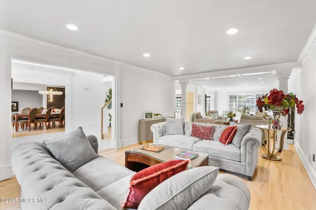 a living room with furniture a large window and a chandelier