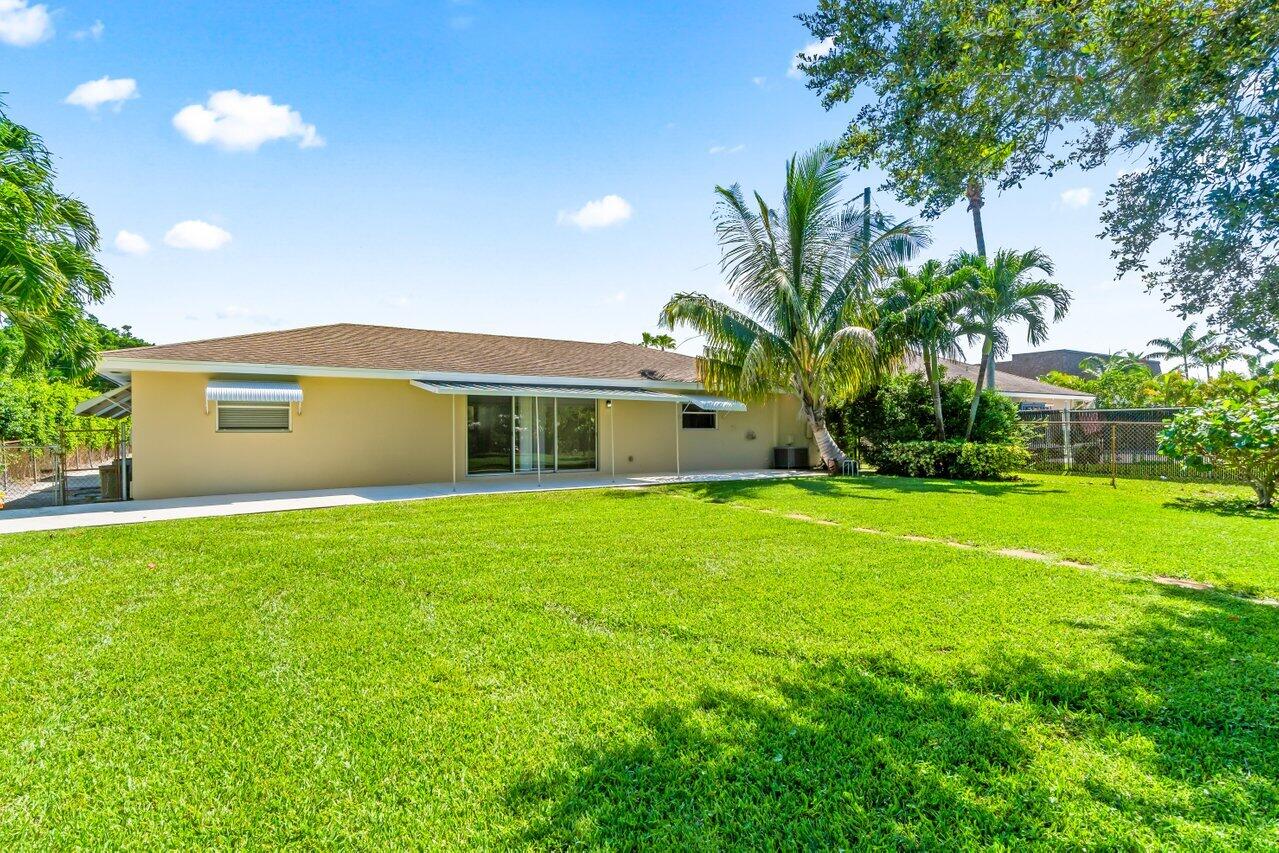751 Hummingbird Way, Unit 7 North Palm Beach, FL 33408 - Photo 34 of 39 a front view of house with yard and green space