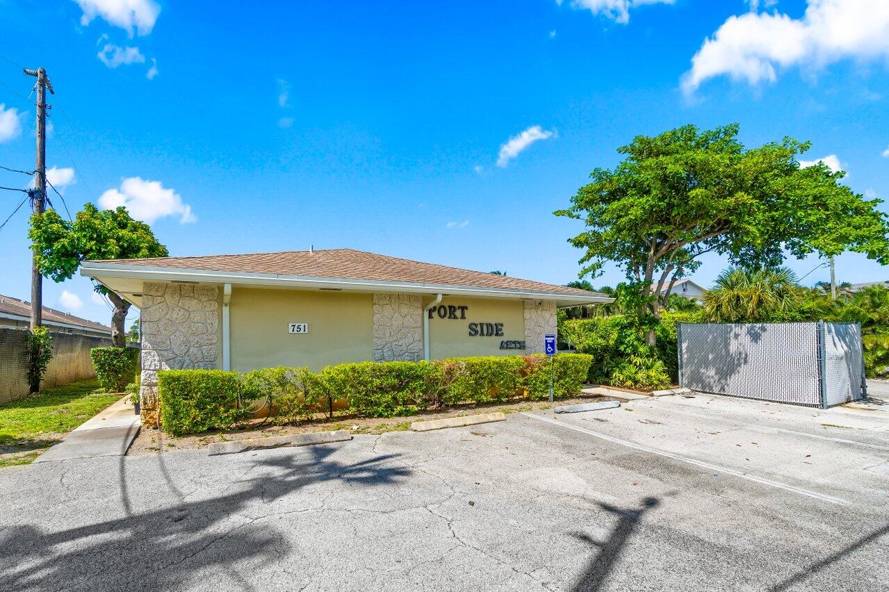 751 Hummingbird Way, Unit 7 North Palm Beach, FL 33408 - Photo 35 of 39 a front view of a house with a yard and a garage
