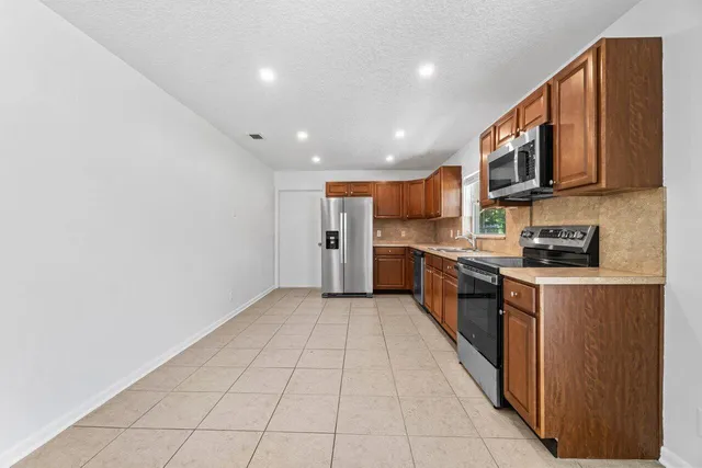 a large kitchen with stainless steel appliances lots of counter top space