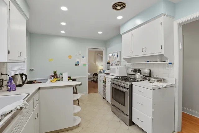 a kitchen that has a lot of cabinets in it and wooden floors