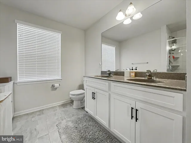 a bathroom with a sink a toilet and a mirror