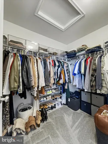 a view of walk in closet with clothes and shoes