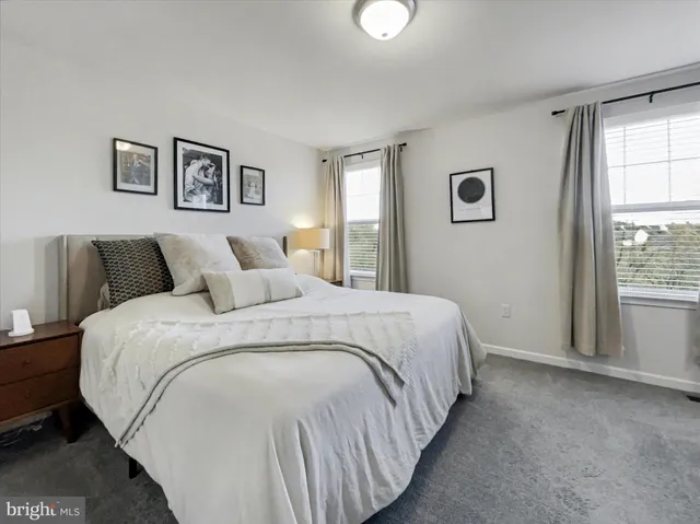 a bedroom with bed and next to a window