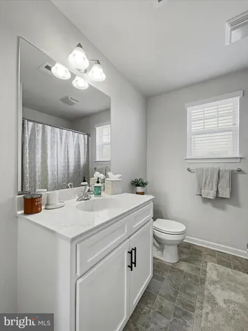 a view of bathroom with a toilet sink and mirror