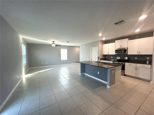 a large kitchen with stainless steel appliances granite countertop a stove a sink and a granite counter tops