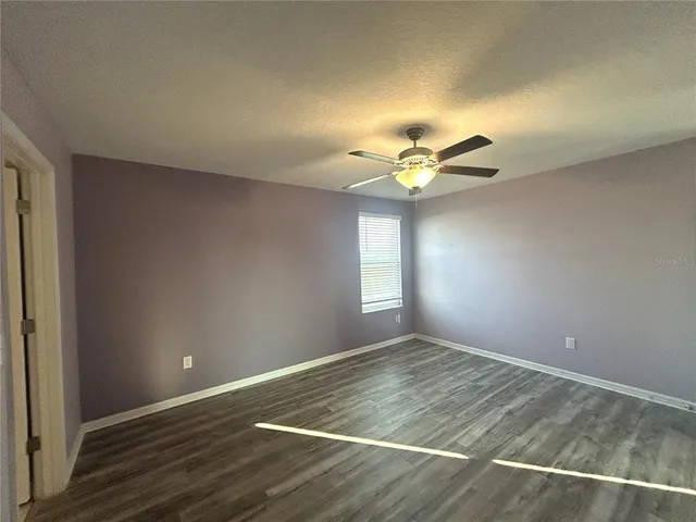 a view of wooden floor and chandelier fan in a room